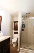 Bathroom with vanity, toilet, an enclosed shower, and tile patterned floors