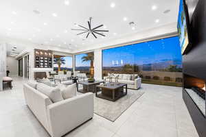 Living room with ceiling fan and light tile patterned flooring