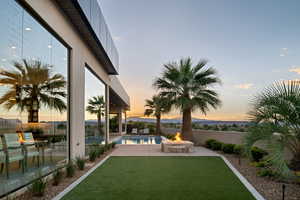 Yard at dusk featuring a fenced in pool, a patio area, and an outdoor fire pit