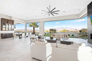 Tiled living room featuring ceiling fan and a mountain view