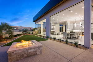 Patio terrace at dusk with ceiling fan and an outdoor fire pit