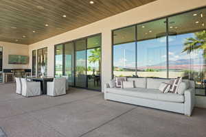 View of patio / terrace with a mountain view, an outdoor hangout area, and exterior kitchen