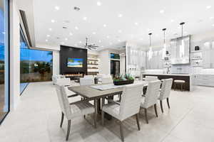 Tiled dining room featuring a fireplace, ceiling fan, and sink