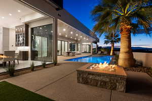 Pool at dusk with a patio area and an outdoor fire pit