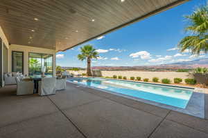 View of swimming pool with a mountain view, a hot tub, and a patio area