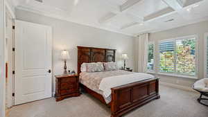 Bedroom with beam ceiling, light colored carpet, and coffered ceiling