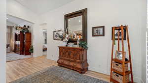 Entry featuring vaulted ceiling and light hardwood / wood-style floors