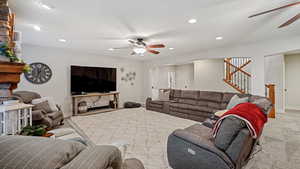 Living room with light carpet, ceiling fan, and a textured ceiling