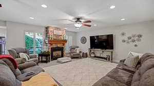 Carpeted living room with a textured ceiling, a fireplace, and ceiling fan