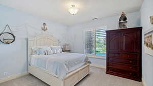 Bedroom with light carpet and a textured ceiling