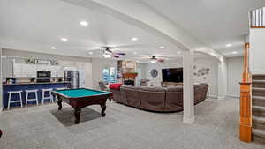 Recreation room featuring light carpet, ceiling fan, a fireplace, and billiards