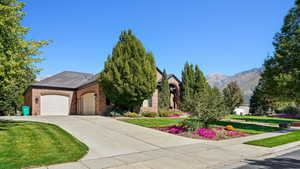 View of front facade featuring a mountain view, a front yard, and a garage