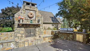 View of patio / terrace featuring a grill, an outdoor stone fireplace, and exterior kitchen