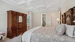 Carpeted bedroom with coffered ceiling, beamed ceiling, and ornamental molding