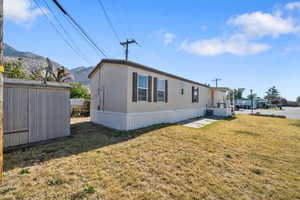 Exterior space featuring a lawn, a mountain view, a storage unit, and central AC unit