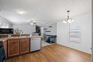 Kitchen featuring dishwasher, wood-type flooring, decorative light fixtures, ornamental molding, and sink