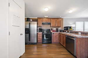 Kitchen featuring sink, appliances with stainless steel finishes, dark hardwood / wood-style flooring, and kitchen peninsula