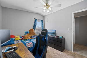 Bedroom featuring ceiling fan, a textured ceiling, vaulted ceiling, and carpet