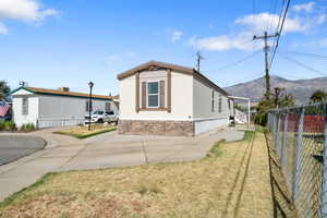 View of side of property with a yard and a mountain view