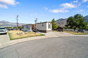 View of front of house with a mountain view and a shed