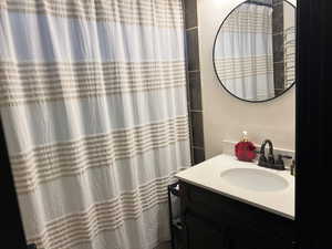 Bathroom with vanity and curtained shower