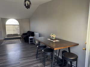 Dining space featuring vaulted ceiling and dark hardwood / wood-style flooring