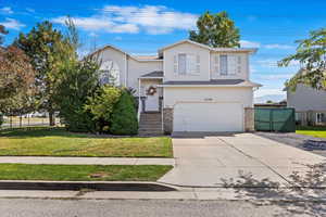 View of front of house featuring a front yard and a garage