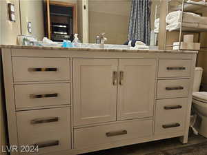 Bathroom featuring wood-type flooring, vanity, and toilet