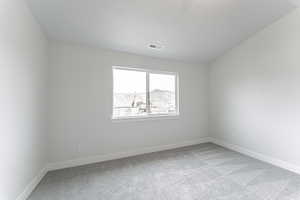 Carpeted spare room with a textured ceiling