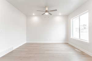 Spare room featuring ceiling fan and light wood-type flooring