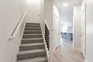 Staircase featuring sink and hardwood / wood-style floors