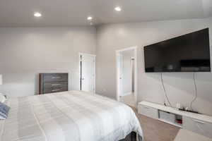 Master bedroom featuring high vaulted ceiling and carpet