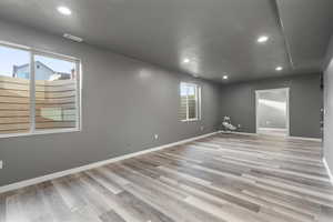 Basement family room with textured ceiling and LVP flooring.