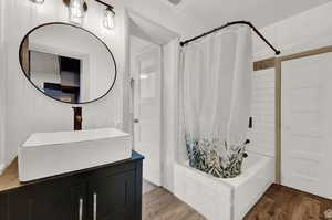 Bathroom featuring shower / bath combo, vanity, and wood-type flooring