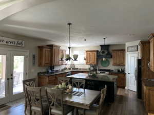 Kitchen with french doors, custom range hood, dark hardwood / wood-style flooring, and a wealth of natural light