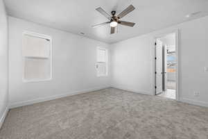 Spare room with light carpet, ceiling fan, and a textured ceiling