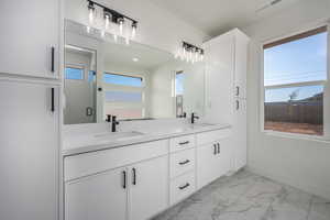 Bathroom featuring vanity, plenty of natural light, and a shower with shower door