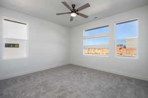 Carpeted spare room with ceiling fan