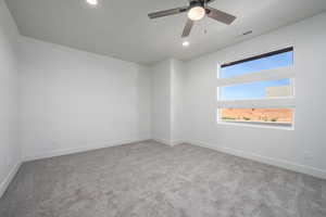 Carpeted spare room with ceiling fan