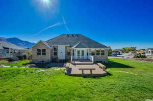 Rear view of house with a patio, a mountain view, and a yard