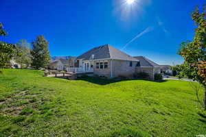 Rear view of property with a wooden deck and a yard