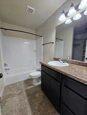 Full bathroom featuring shower / bath combination, vanity, a textured ceiling, tile patterned flooring, and toilet