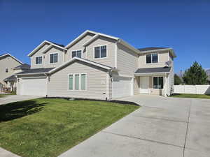 View of front property featuring a front lawn and a garage