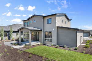 Rear view of house featuring a garage, a patio area, and a yard