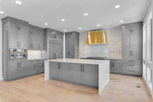 Kitchen with gray cabinets, stainless steel appliances, and light hardwood / wood-style flooring