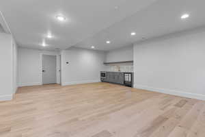 Unfurnished living room featuring light hardwood / wood-style floors and sink