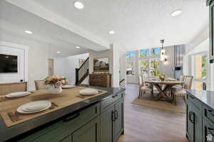 Kitchen with pendant lighting, light hardwood / wood-style floors, and a textured ceiling