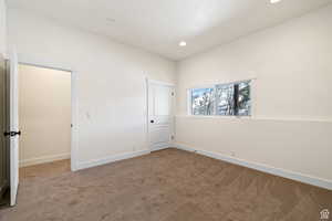 Unfurnished bedroom featuring light carpet and a closet