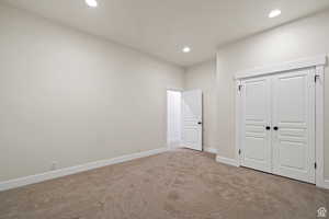 Unfurnished bedroom featuring light colored carpet and a closet