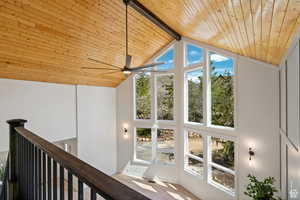 Unfurnished sunroom featuring lofted ceiling with beams, wood ceiling, and a healthy amount of sunlight